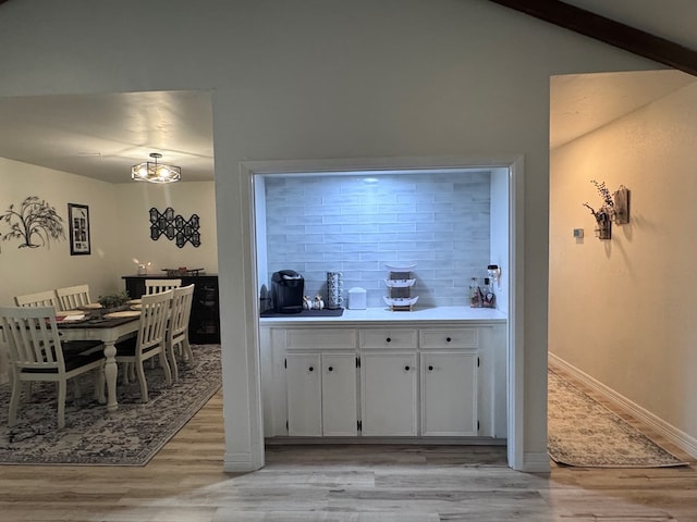 3212 Fannin Ave, Midland, TX 79705 - kitchen with decorative backsplash, light wood-style flooring, white cabinets, beamed ceiling, and light countertops