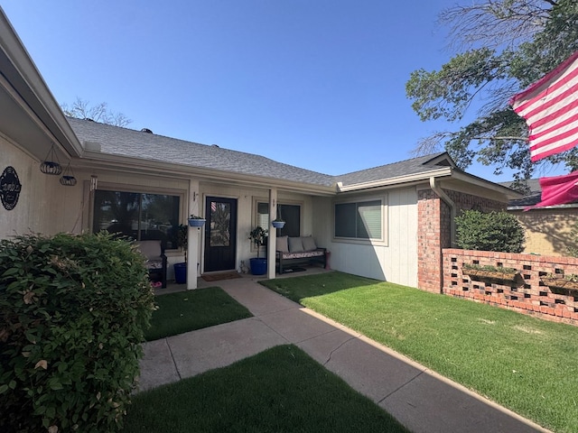 3212 Fannin Ave, Midland, TX 79705 - doorway to property featuring a lawn, a shingled roof, and brick siding