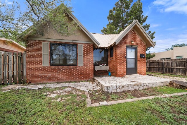 407 Edwards Blvd, Big Spring, TX 79720 - view of front facade with brick siding, a patio, and a metal roof