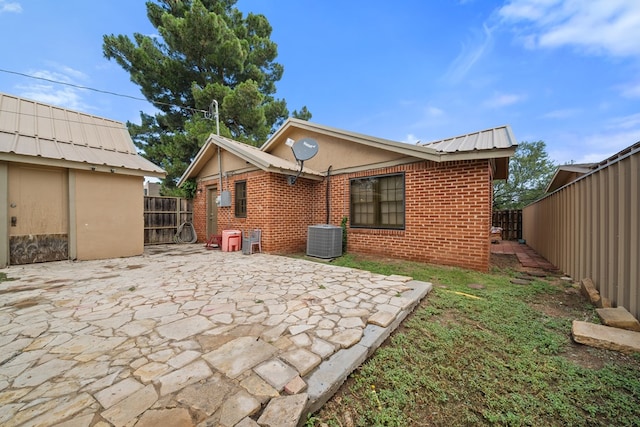 407 Edwards Blvd, Big Spring, TX 79720 - rear view of property featuring brick siding, a fenced backyard, a patio, and a metal roof