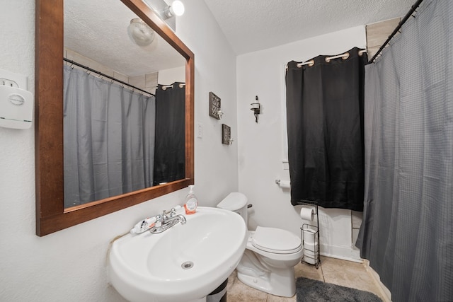 407 Edwards Blvd, Big Spring, TX 79720 - full bathroom featuring a textured ceiling, tile patterned flooring, and a shower with curtain