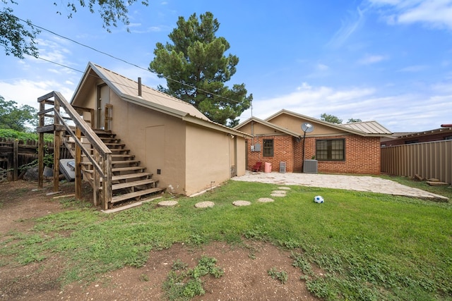 407 Edwards Blvd, Big Spring, TX 79720 - back of property with stairs, stucco siding, and a patio