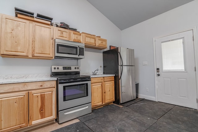 4100 Skyline Dr, Midland, TX 79707 - kitchen featuring appliances with stainless steel finishes, vaulted ceiling, light countertops, and light brown cabinetry