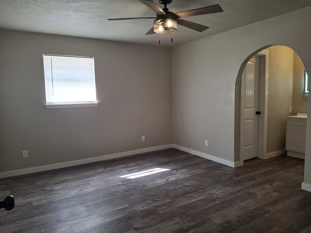 4011 Houston Ave, Snyder, TX 79549 - spare room with arched walkways, ceiling fan, baseboards, and dark wood-type flooring