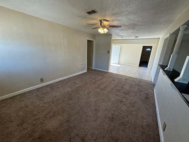 unfurnished room featuring a textured ceiling, ceiling fan, and light carpet