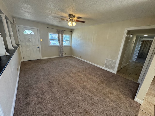 carpeted entryway with ceiling fan and a textured ceiling