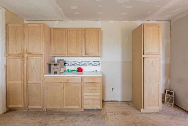 kitchen featuring light brown cabinetry and tasteful backsplash