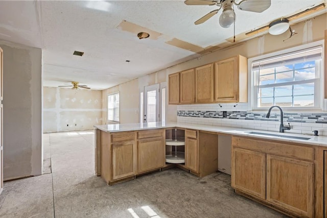 kitchen featuring sink, decorative backsplash, kitchen peninsula, and ceiling fan