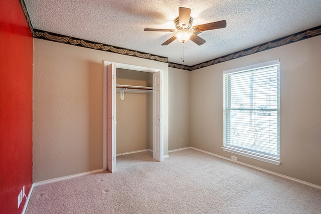 unfurnished bedroom with light carpet, baseboards, ceiling fan, a textured ceiling, and a closet