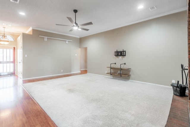 interior space featuring ornamental molding, wood finished floors, visible vents, and baseboards