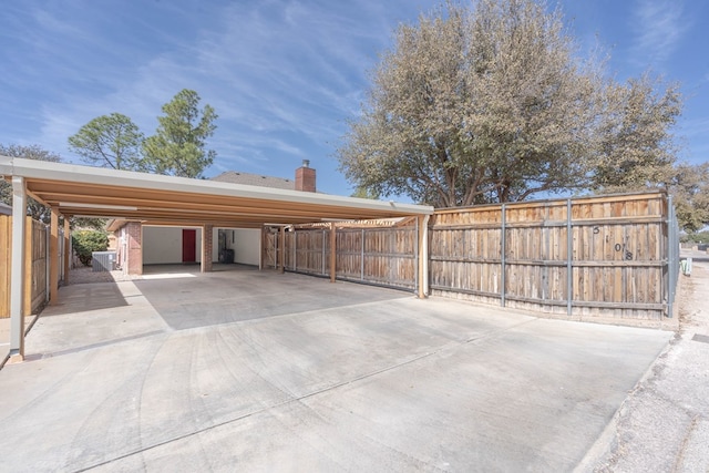 view of car parking with driveway and fence