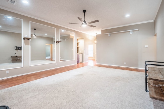 spare room featuring visible vents, a ceiling fan, and crown molding