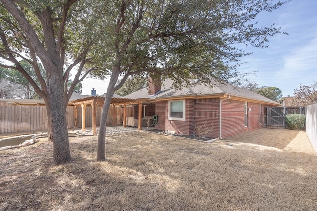 rear view of property with a patio area, a fenced backyard, a chimney, and brick siding