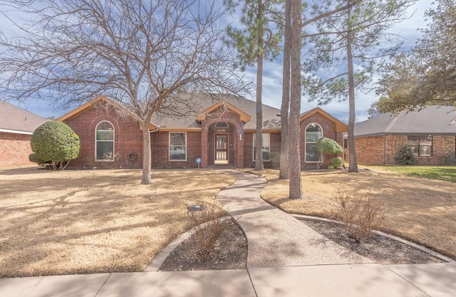 view of front of house with a shingled roof and brick siding