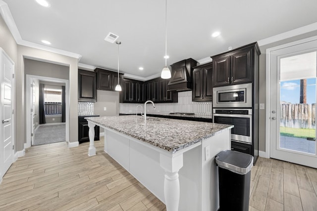 1803 Overshine Ln, Midland, TX 79705 - kitchen featuring stainless steel appliances, custom exhaust hood, tasteful backsplash, light stone countertops, and recessed lighting