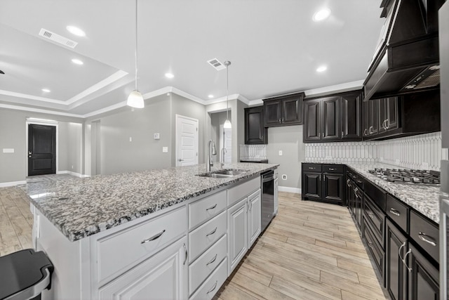 1803 Overshine Ln, Midland, TX 79705 - kitchen with premium range hood, appliances with stainless steel finishes, decorative backsplash, light stone counters, and ornamental molding