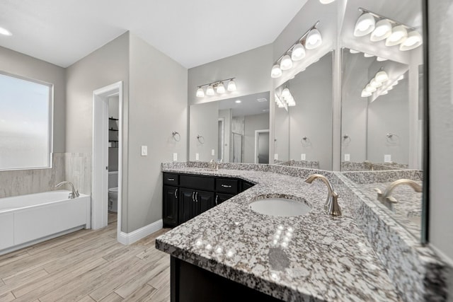 1803 Overshine Ln, Midland, TX 79705 - bathroom featuring vanity, a bath, and wood finished floors