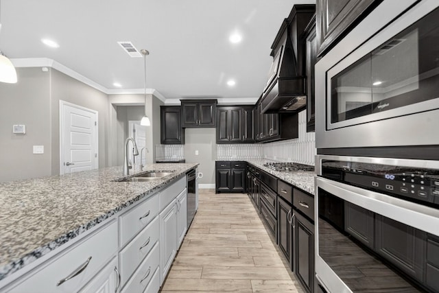 1803 Overshine Ln, Midland, TX 79705 - kitchen featuring stainless steel appliances, ornamental molding, light stone counters, light wood finished floors, and pendant lighting