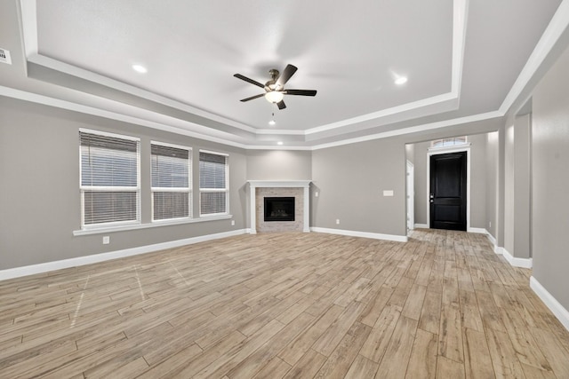 1803 Overshine Ln, Midland, TX 79705 - unfurnished living room featuring a tray ceiling, ceiling fan, light wood-style floors, a fireplace, and recessed lighting