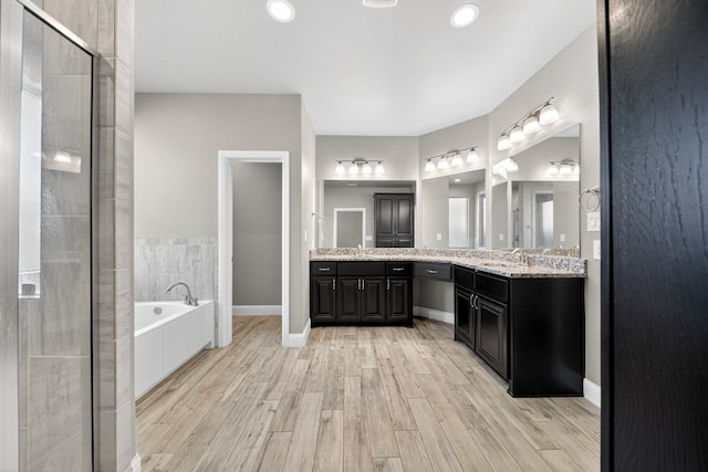1803 Overshine Ln, Midland, TX 79705 - full bath featuring a bath, vanity, wood finished floors, a shower stall, and recessed lighting