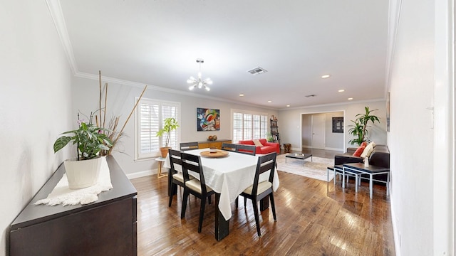 dining room featuring a chandelier, baseboards, visible vents, and ornamental molding