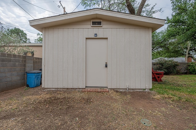 view of shed featuring fence
