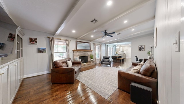 living area with visible vents, a fireplace, ceiling fan, dark wood-type flooring, and lofted ceiling with beams