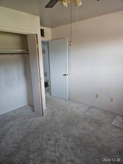 unfurnished bedroom with ceiling fan, carpet floors, and a closet