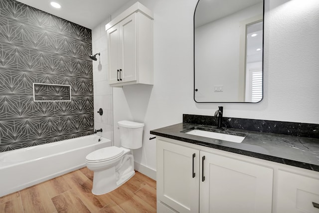 full bathroom with wood-type flooring, toilet, tiled shower / bath combo, and vanity