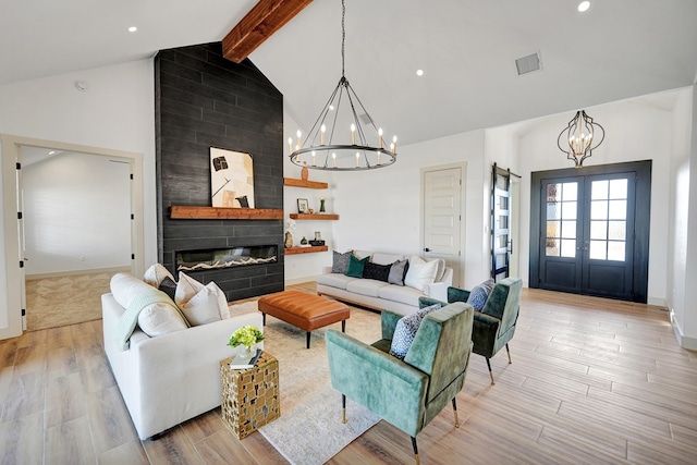 living room featuring french doors, beam ceiling, an inviting chandelier, a fireplace, and light hardwood / wood-style floors