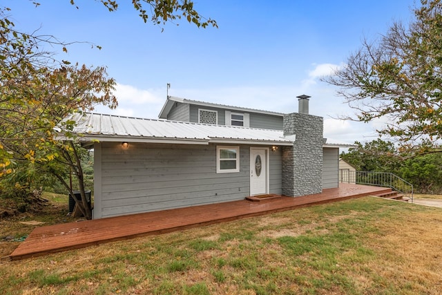 905 Ridgeway, Burnet, TX 78611 - back of property with a yard, a deck, a chimney, and a metal roof