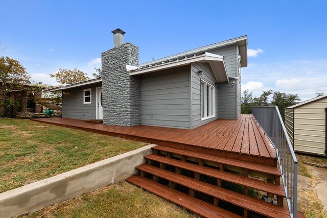 905 Ridgeway, Burnet, TX 78611 - back of house with a wooden deck, a yard, a metal roof, and a chimney