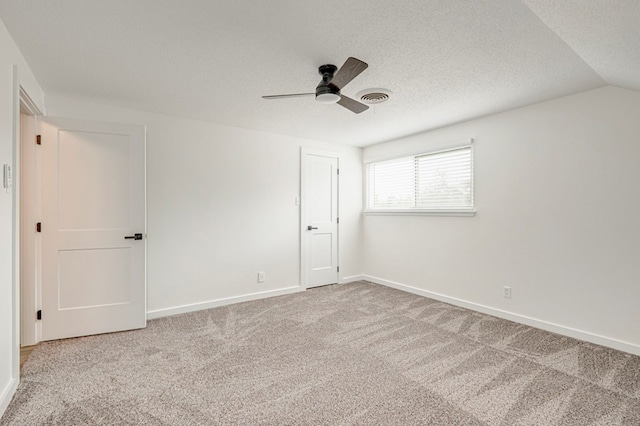 unfurnished bedroom with a ceiling fan, visible vents, carpet, baseboards, and a textured ceiling