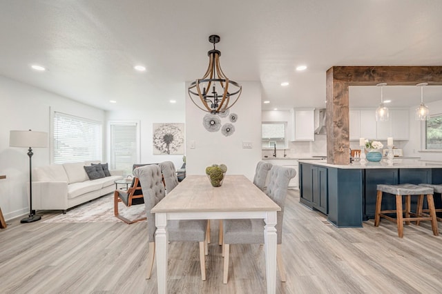 dining room featuring a healthy amount of sunlight, recessed lighting, light wood-style flooring, and a notable chandelier