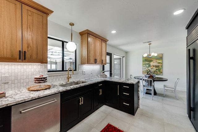 909 Pine Ct, Midland, TX 79705 - kitchen with stainless steel dishwasher, decorative backsplash, a peninsula, light stone countertops, and recessed lighting