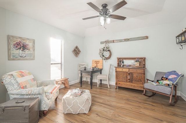 sitting room with ceiling fan and wood-type flooring