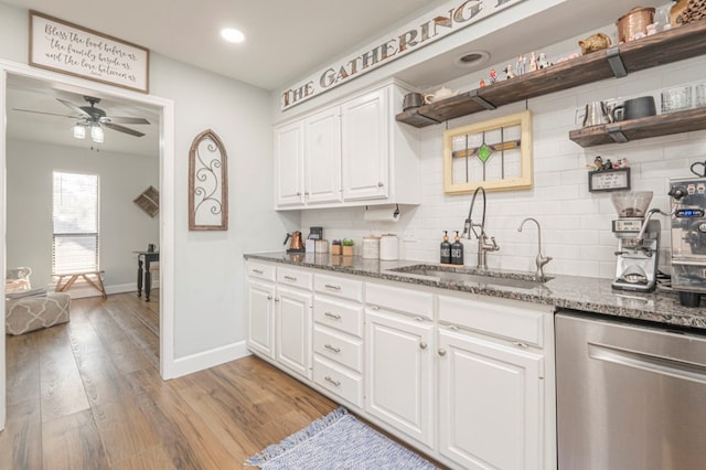 kitchen with sink, white cabinetry, light wood-type flooring, dishwasher, and backsplash