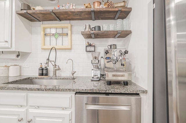 kitchen featuring stainless steel appliances, light stone countertops, and white cabinets