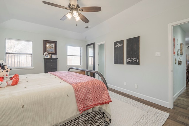 bedroom featuring a tray ceiling, dark hardwood / wood-style floors, and ceiling fan