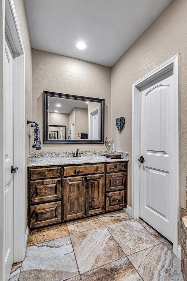 1210 S County Rd 1117, Midland, TX 79706 - bathroom featuring vanity, a textured wall, and stone finish floors