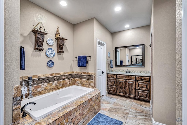 1210 S County Rd 1117, Midland, TX 79706 - bathroom with a jetted tub, vanity, recessed lighting, and a textured wall