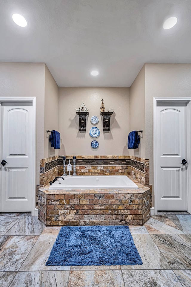 1210 S County Rd 1117, Midland, TX 79706 - bathroom featuring a garden tub and stone tile flooring
