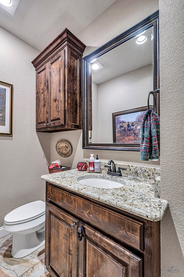1210 S County Rd 1117, Midland, TX 79706 - half bath with vanity, toilet, and a textured wall