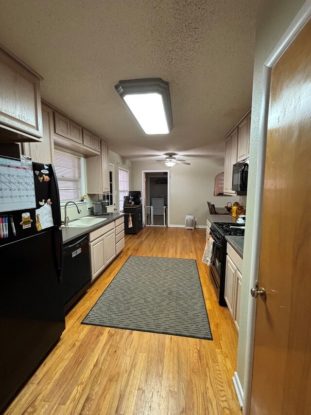 1806 38th St, Snyder, TX 79549 - kitchen with black appliances, a sink, light wood-style flooring, a ceiling fan, and a textured ceiling