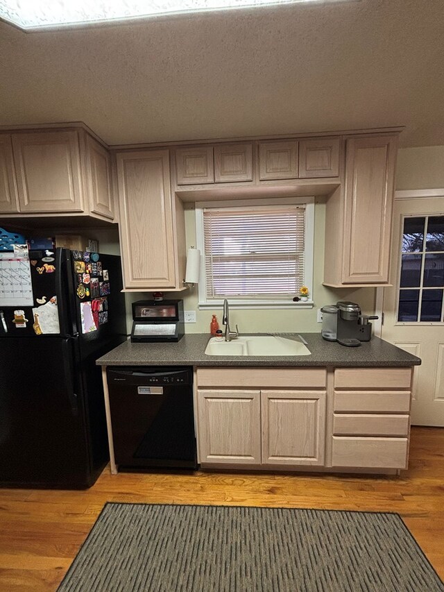 1806 38th St, Snyder, TX 79549 - kitchen with black appliances, a sink, dark countertops, light wood finished floors, and a textured ceiling