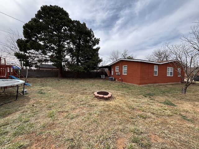 1806 38th St, Snyder, TX 79549 - view of yard featuring an outdoor fire pit, a trampoline, and central AC unit