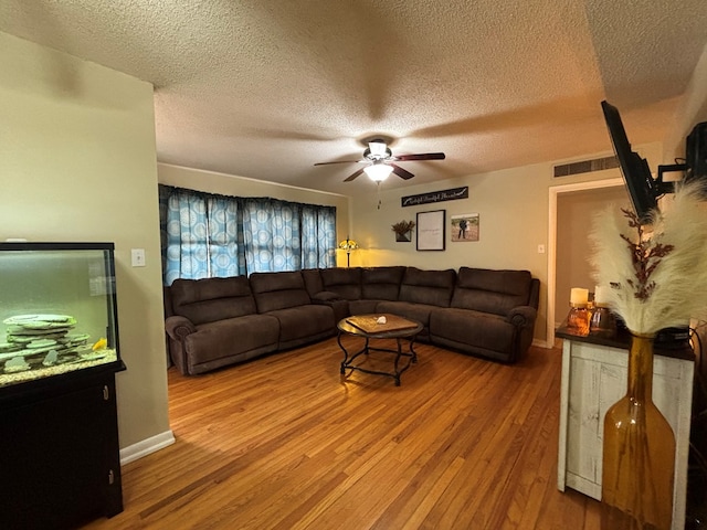1806 38th St, Snyder, TX 79549 - living area featuring wood finished floors, a ceiling fan, a textured ceiling, and baseboards