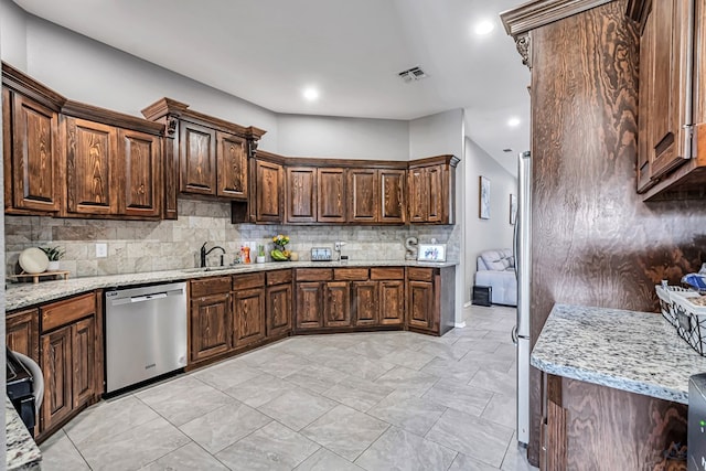 1321 Pine Ave, Midland, TX 79705 - kitchen with stainless steel appliances, decorative backsplash, light stone counters, dark brown cabinets, and recessed lighting