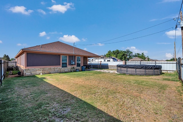 1321 Pine Ave, Midland, TX 79705 - back of property featuring a fenced backyard, stone siding, and roof with shingles