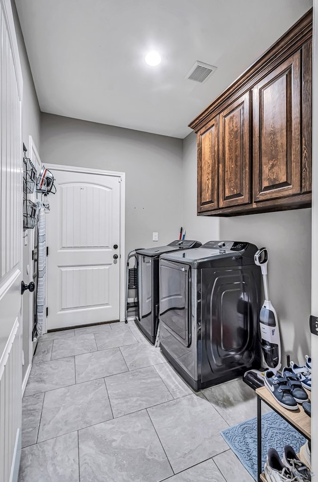 1321 Pine Ave, Midland, TX 79705 - laundry area featuring washing machine and clothes dryer, light marble finish floors, and cabinet space